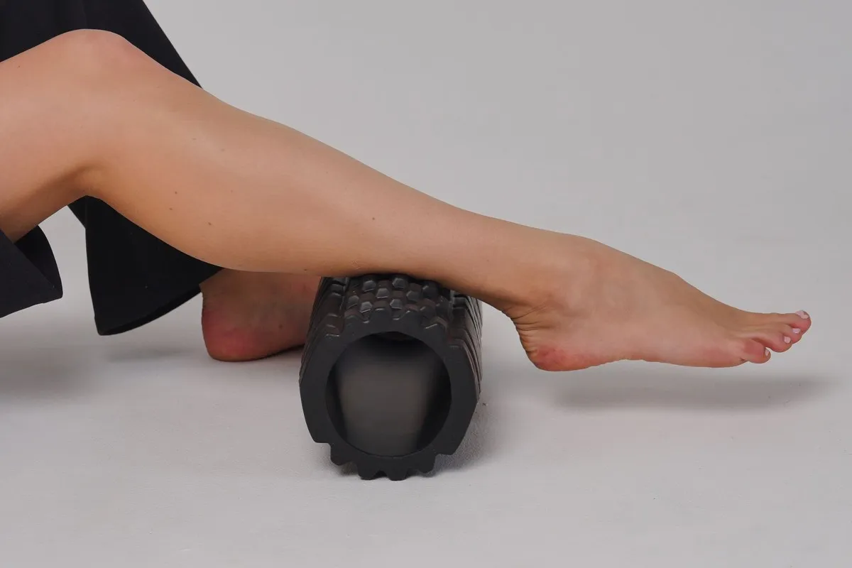 Kuit rollen op een zwarte foam roller met noppen
