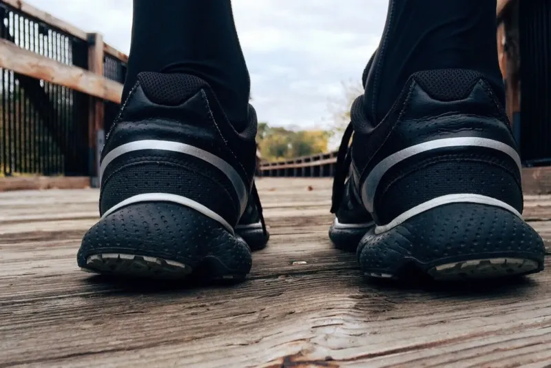 Close-up van hardloopschoenen van een loper op een houten brug in de ochtend