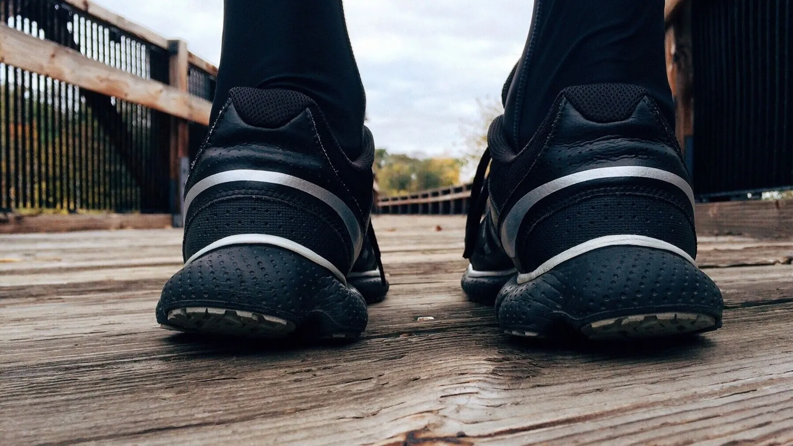 Close-up van hardloopschoenen van een loper op een houten brug in de ochtend