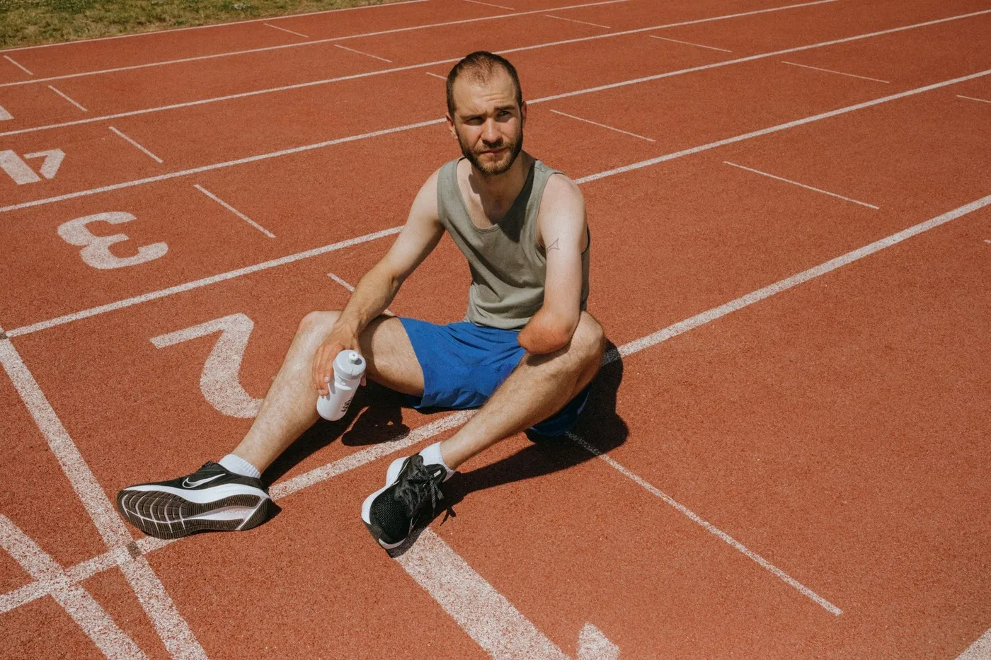 Hardloper rust uit op de atletiekbaan na een training